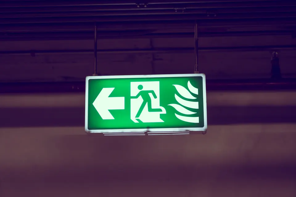 Signal lumineux indiquant une issue de secours vers la gauche